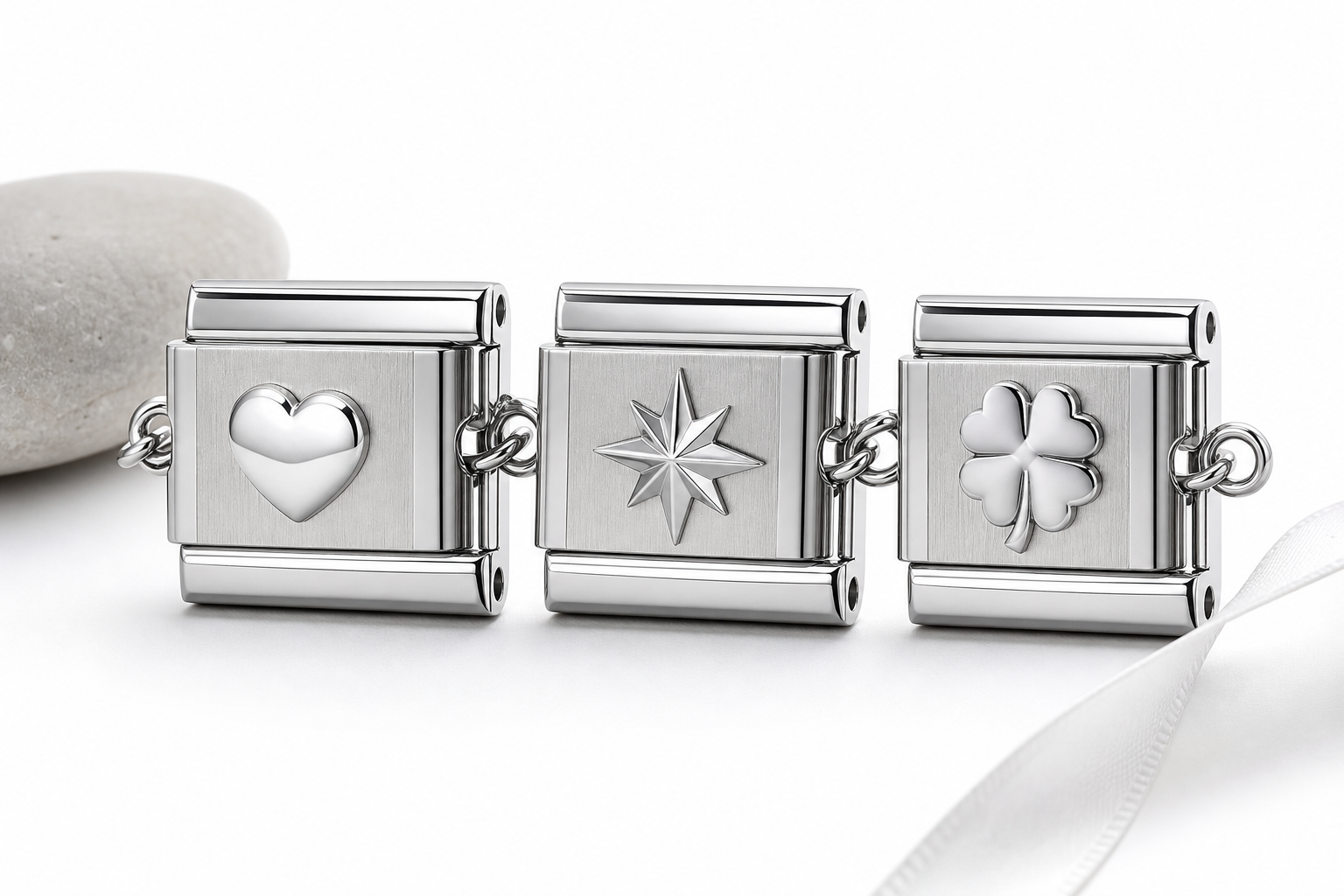 Close-up of a polished 316L stainless steel Italian charm on a white background, showing the bail and engraving details.