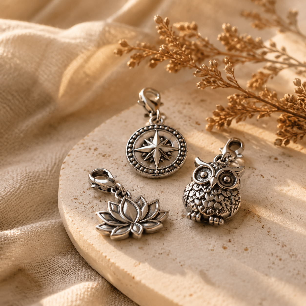 premium stainless steel charm collection arranged on a neutral boutique display tray